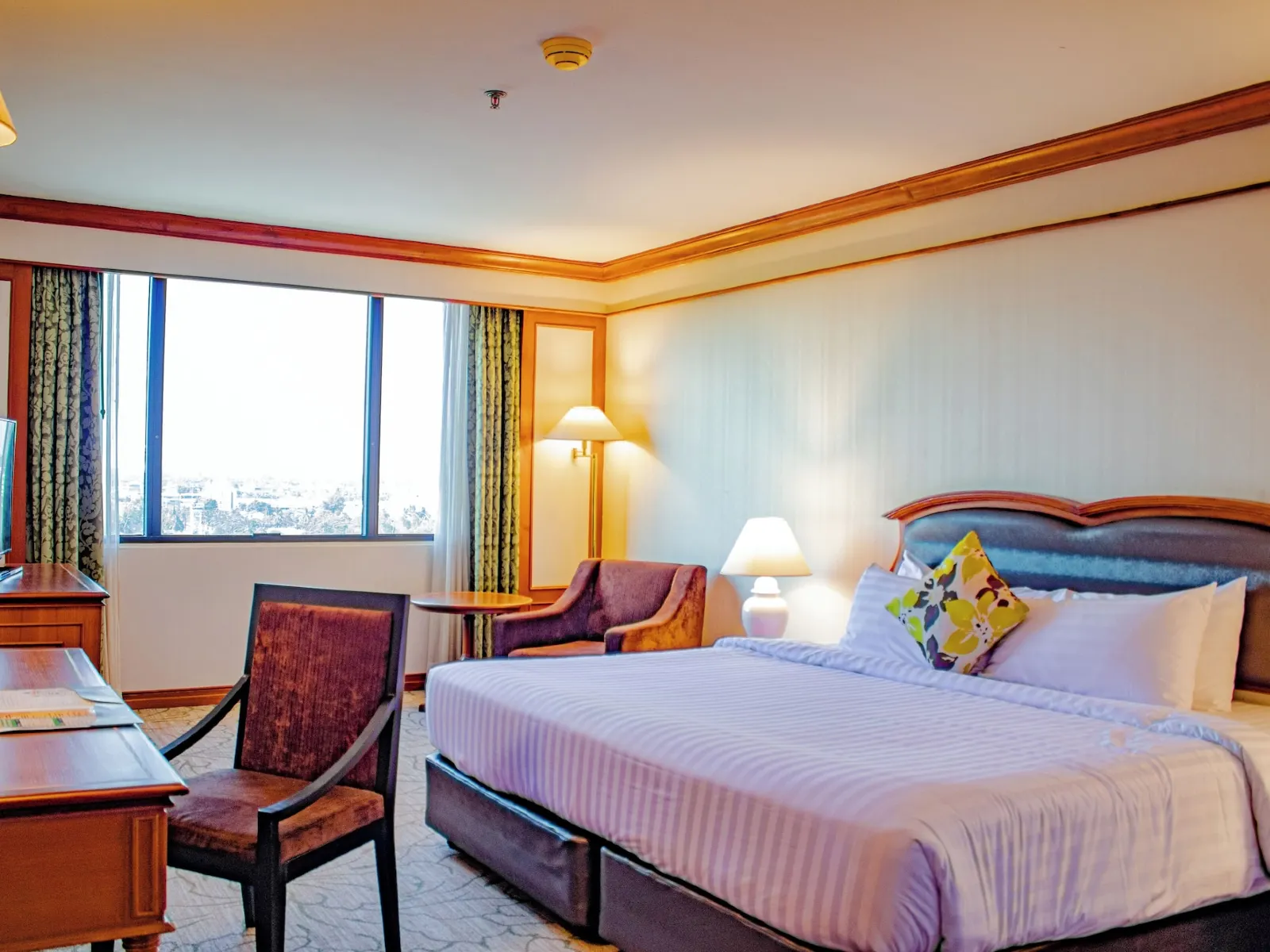 ห้องพักของ The Twin Lotus Hotel เตียงใหญ่ ผ้าปูสีขาวสะอาด พร้อมหน้าต่างมองวิวเมือง