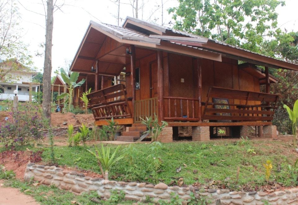 ห้องพักตกแต่งงานไม้โทนอบอุ่นพร้อมระเบียงมองวิวลำธารและภูเขาที่ Boklua River Villa