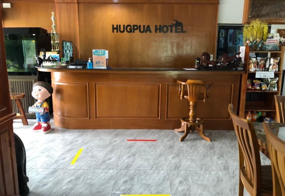 ห้องพักภายในของ Hugpua Hotel ตกแต่งด้วยไม้ มีเตียง ทีวี และเครื่องปรับอากาศ