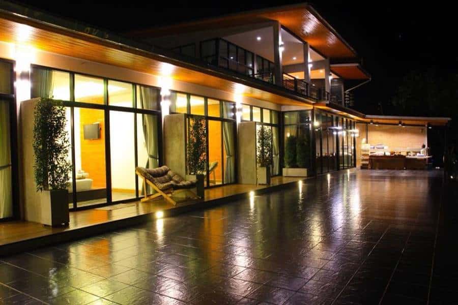 มุมห้องพักสไตล์ลอฟต์ของ Pagoda Sight Residence น่าน เพดานสูงพร้อมผนังกระจกมองออกทุ่งและภูเขา