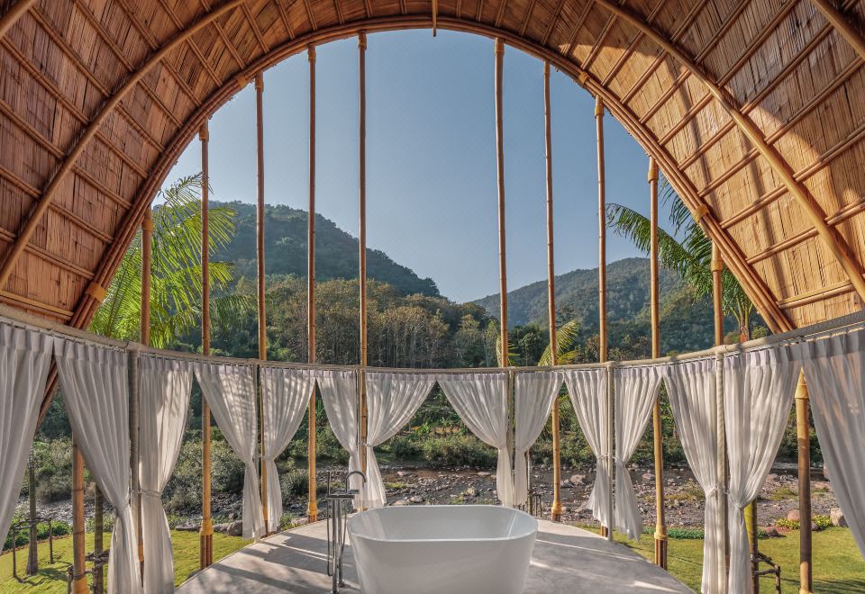 ภายในวิลล่าของ Phukananan Resort มีเตียงและระเบียงมองออกไปเห็นวิวเขา