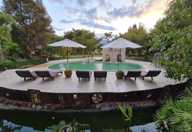 บังกะโลแอร์มีระเบียงส่วนตัว วางกลางสวนและทุ่งนาที่ Pai My Guest Resort