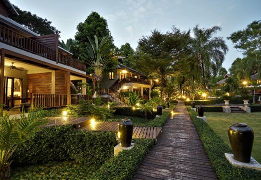สระว่ายน้ำกลางแจ้งของ The Quarter Pai ล้อมรอบด้วยสวนเขียว