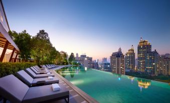 สระว่ายน้ำ Infinity 40 เมตรชั้น 9 ของ Park Hyatt Bangkok ล้อมรอบด้วยสวนเขตร้อนและเก้าอี้นอนผ่อนคลาย วิวเมืองกรุงเทพ