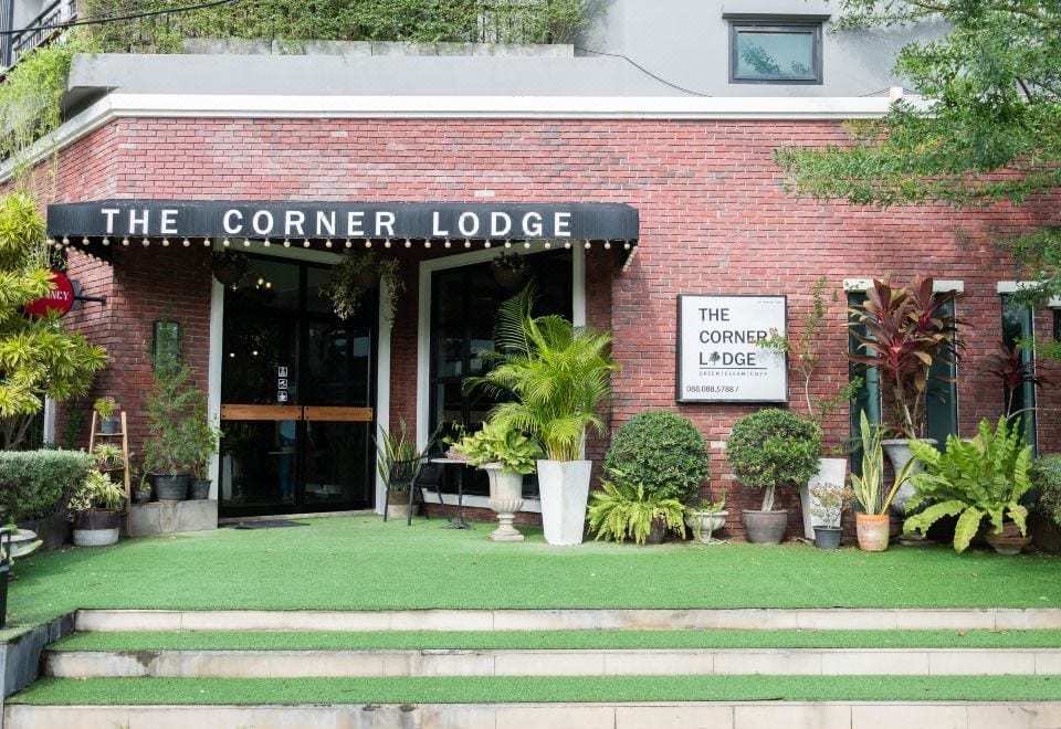ห้องพักของ The Corner Lodge พัทยา โทนสว่างสะอาดตา เตียงนุ่ม พร้อมโต๊ะและตู้เย็น