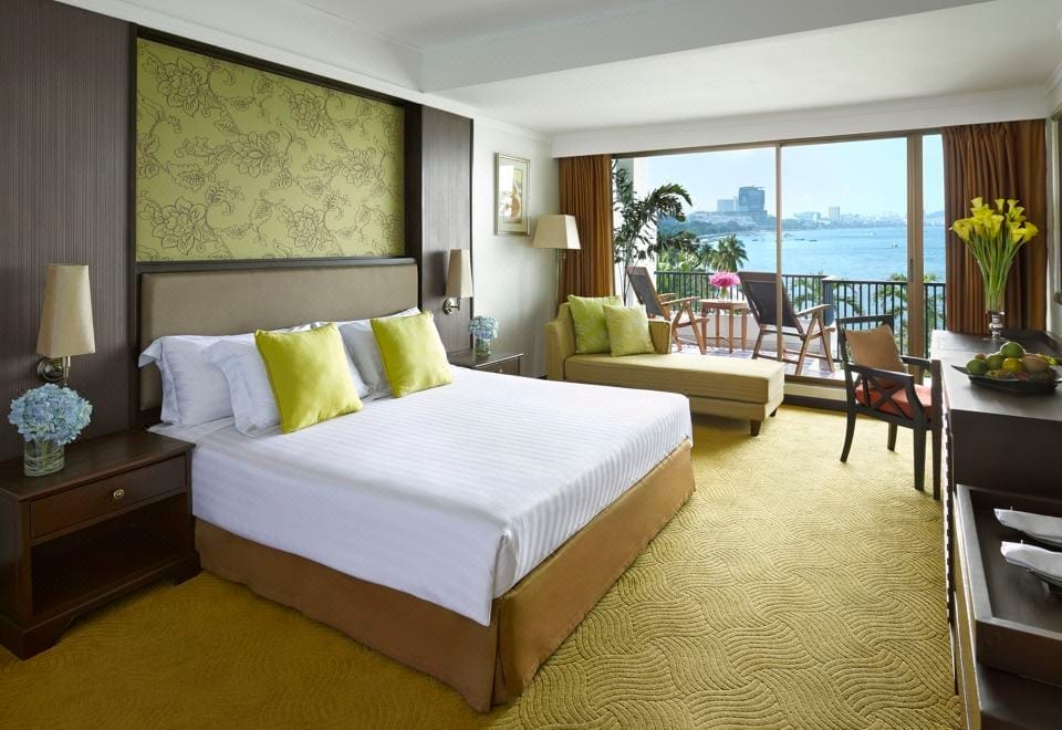 สระว่ายน้ำกลางแจ้งของ Dusit Thani Pattaya มองออกอ่าวพัทยาท่ามกลางสวนเขตร้อน