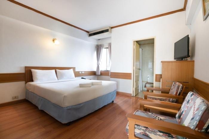 ห้องพักของ Mike Hotel Pattaya โทนไม้สีอ่อน เตียงใหญ่ ห้องกว้าง พร้อมหน้าต่างรับแสงและห้องน้ำในตัว