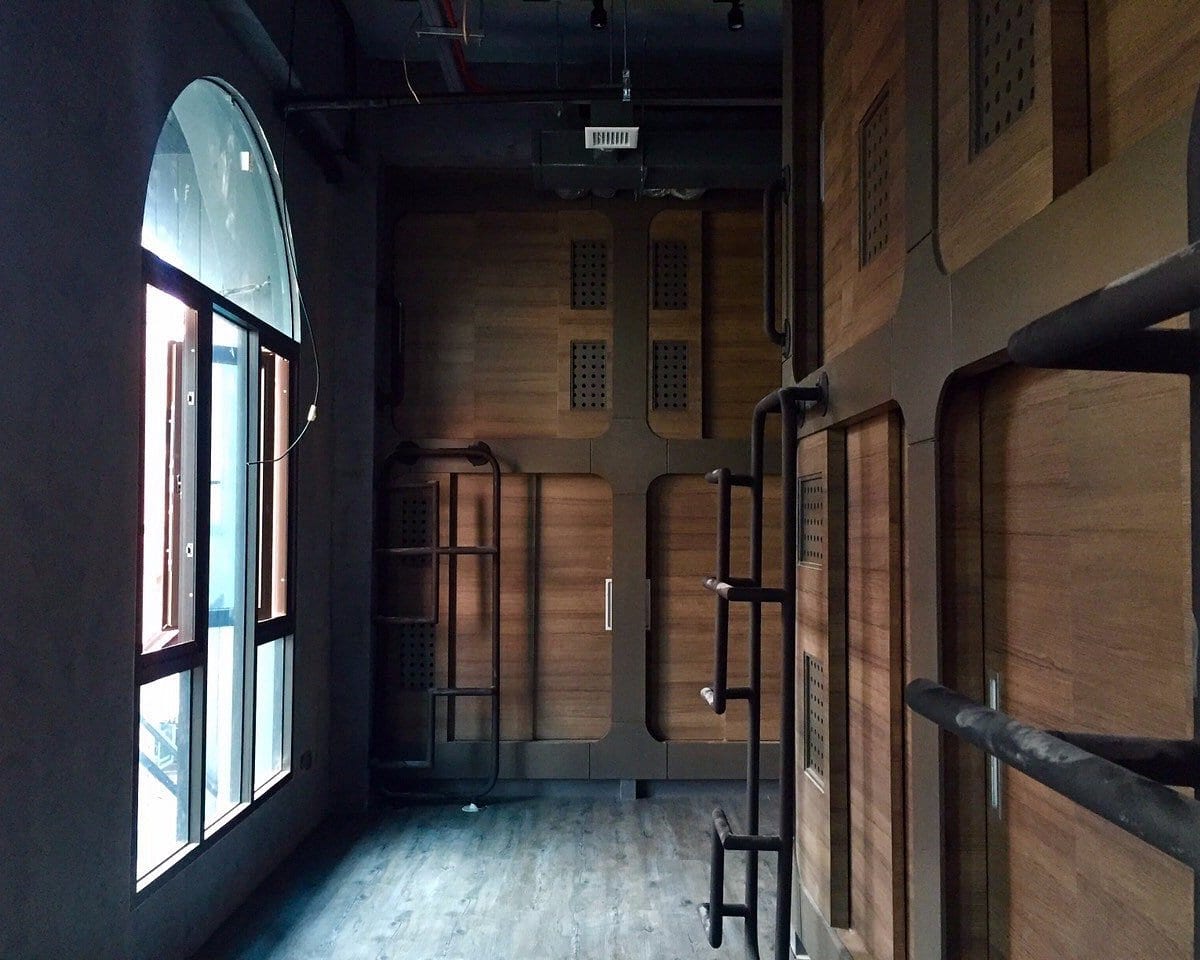 แคปซูลของ Nonze Hostel พัทยา ตกแต่งโทนเหลือง มีประตูเลื่อนส่วนตัวและไฟอ่านหนังสือ
