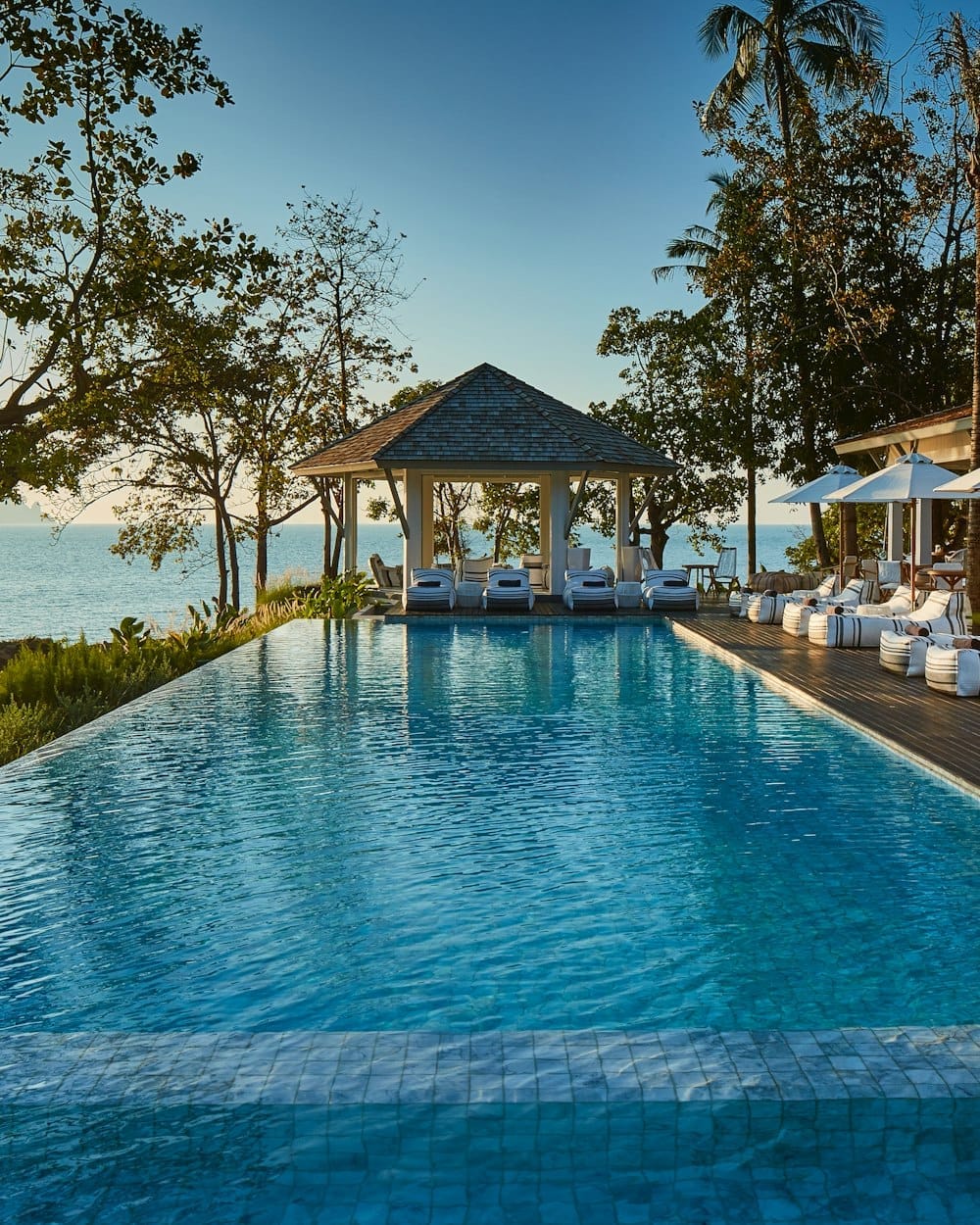 สระว่ายน้ำหลักของ Cape Kudu Hotel มองออกไปเห็นทะเลและเขาหินปูนอ่าวพังงา