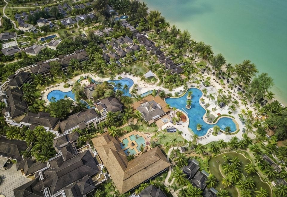 ภาพมุมสูงของ ROBINSON Club Khao Lak เห็นสระว่ายน้ำและพื้นที่สวนกว้างติดหาด Pak Weep
