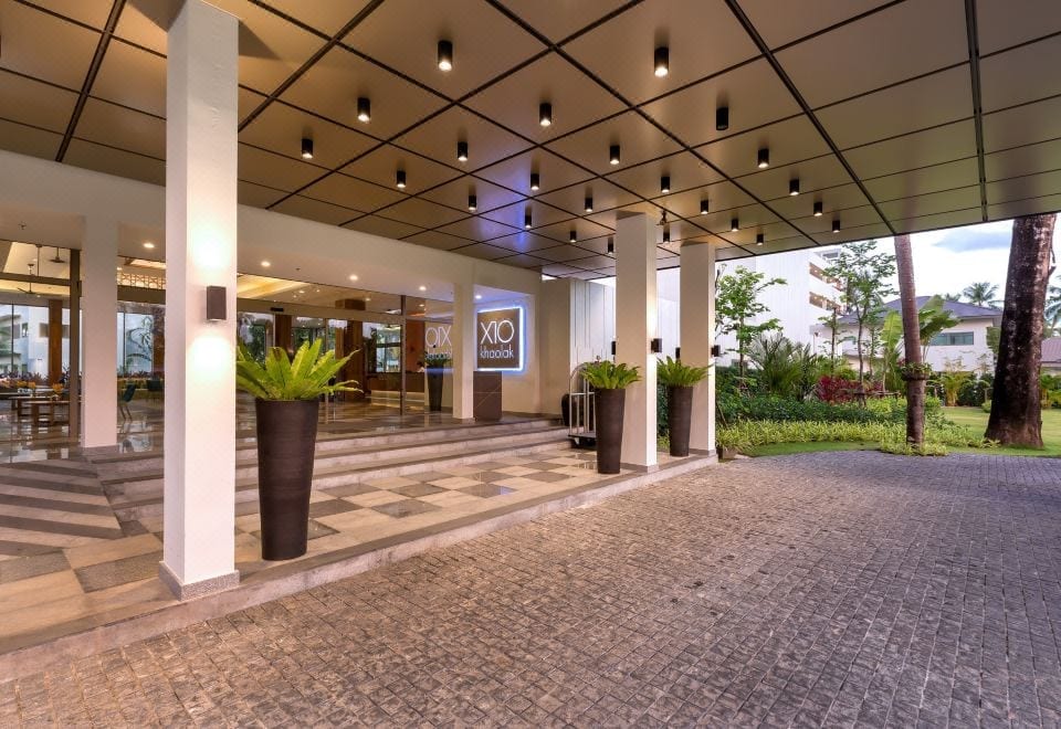 สระว่ายน้ำกลางแจ้งของ X10 Khaolak Resort ท่ามกลางสวนและแนวต้นปาล์มริมหาดเขาหลัก