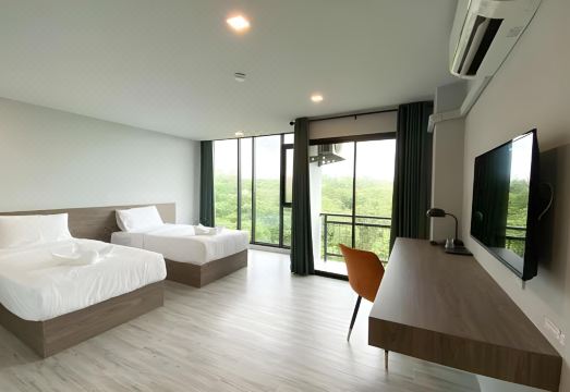 มุมห้องพักของ Dee Hotel Phayao พร้อมทีวี ตู้เย็น และโต๊ะ