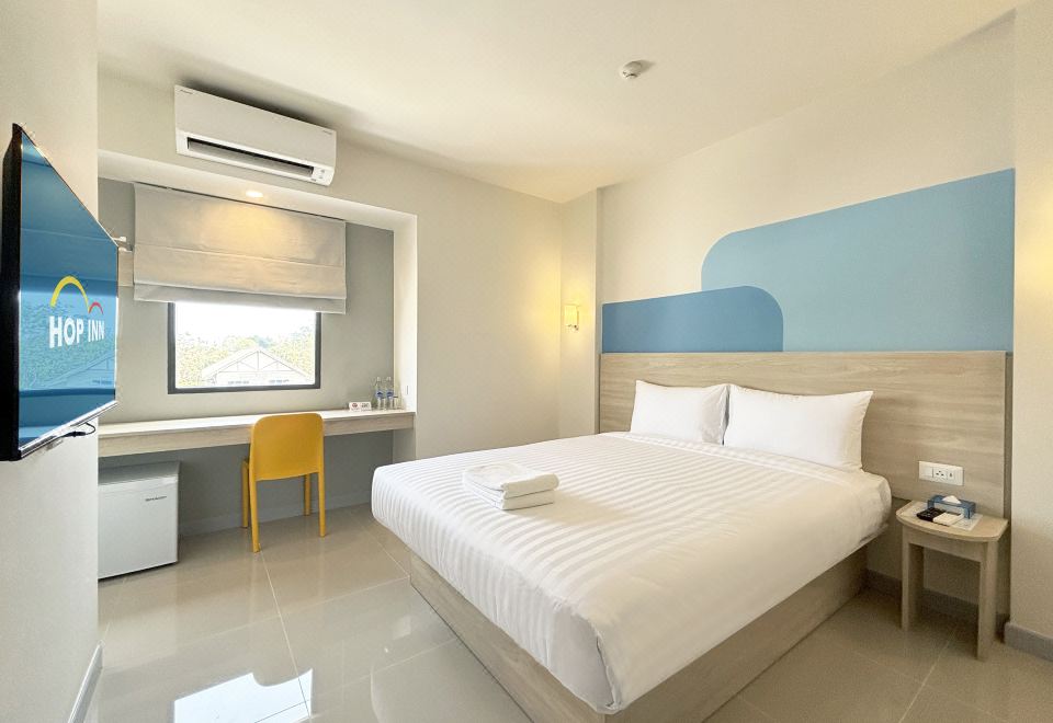 มุมห้องพักของ Hop Inn Phayao พร้อมโต๊ะทำงาน ทีวีจอแบน และตู้เย็น
