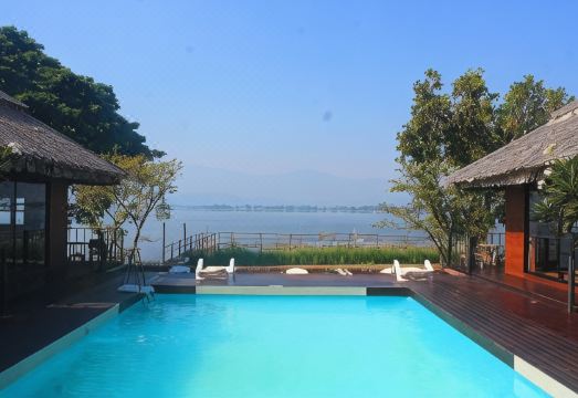 ห้องพักของ Naga Tara Boutique Resort พะเยา ตกแต่งโทนอบอุ่น มีระเบียงส่วนตัว