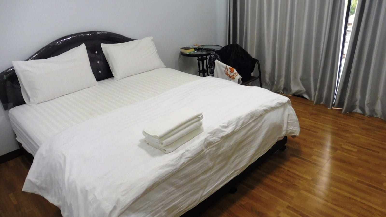 ห้องพักภายใน Dusita Residence เพชรบูรณ์ เตียงสะอาด มีโต๊ะทำงานและทีวีจอแบน