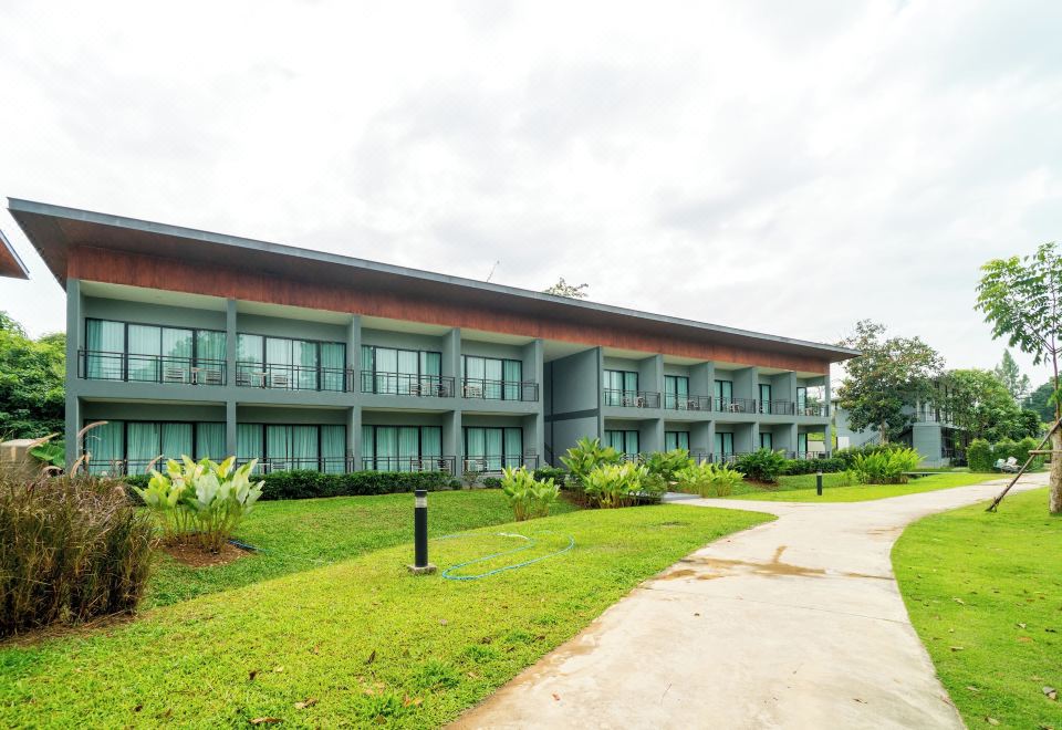 สระว่ายน้ำฟรีฟอร์มในสวนของ The Tree Riverside Resort ริมแม่น้ำแก่งกระจาน