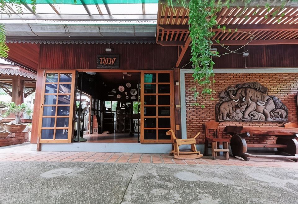 มุมสวนและระเบียงไม้ของ Baanthep Antique Homestay บรรยากาศเมืองเก่าแพร่