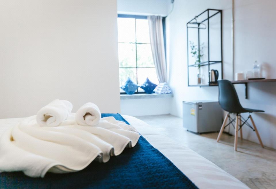 ห้องพักสไตล์ลอฟต์ของ Hug Inn Phrae ผนังปูนเปลือยผสมของตกแต่งหม้อห้อมท้องถิ่น