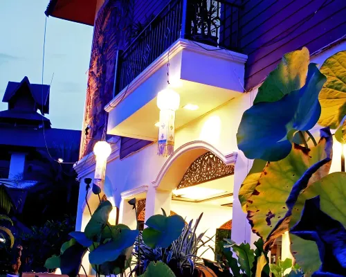 สวนเขียวร่มรื่นและตัวอาคารล้านนาของ PhoomThai Garden Hotel แพร่