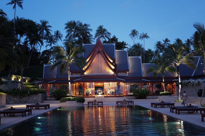 Amanpuri's black-tiled swimming pool and Thai-roofed pavilion at dusk