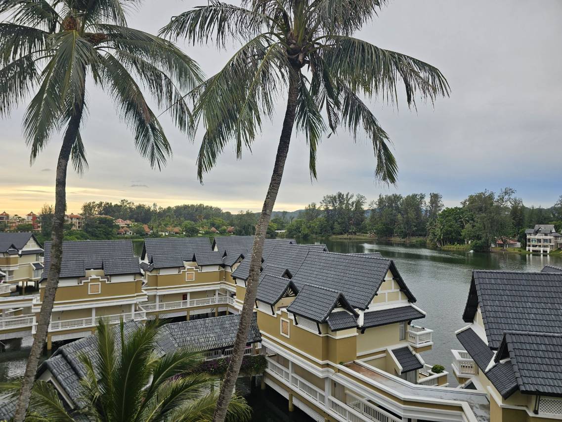 อาคารห้องพักสีเหลืองหลังคาทรงไทยของ Angsana Laguna Phuket เรียงตัวริมลากูนท่ามกลางต้นมะพร้าว