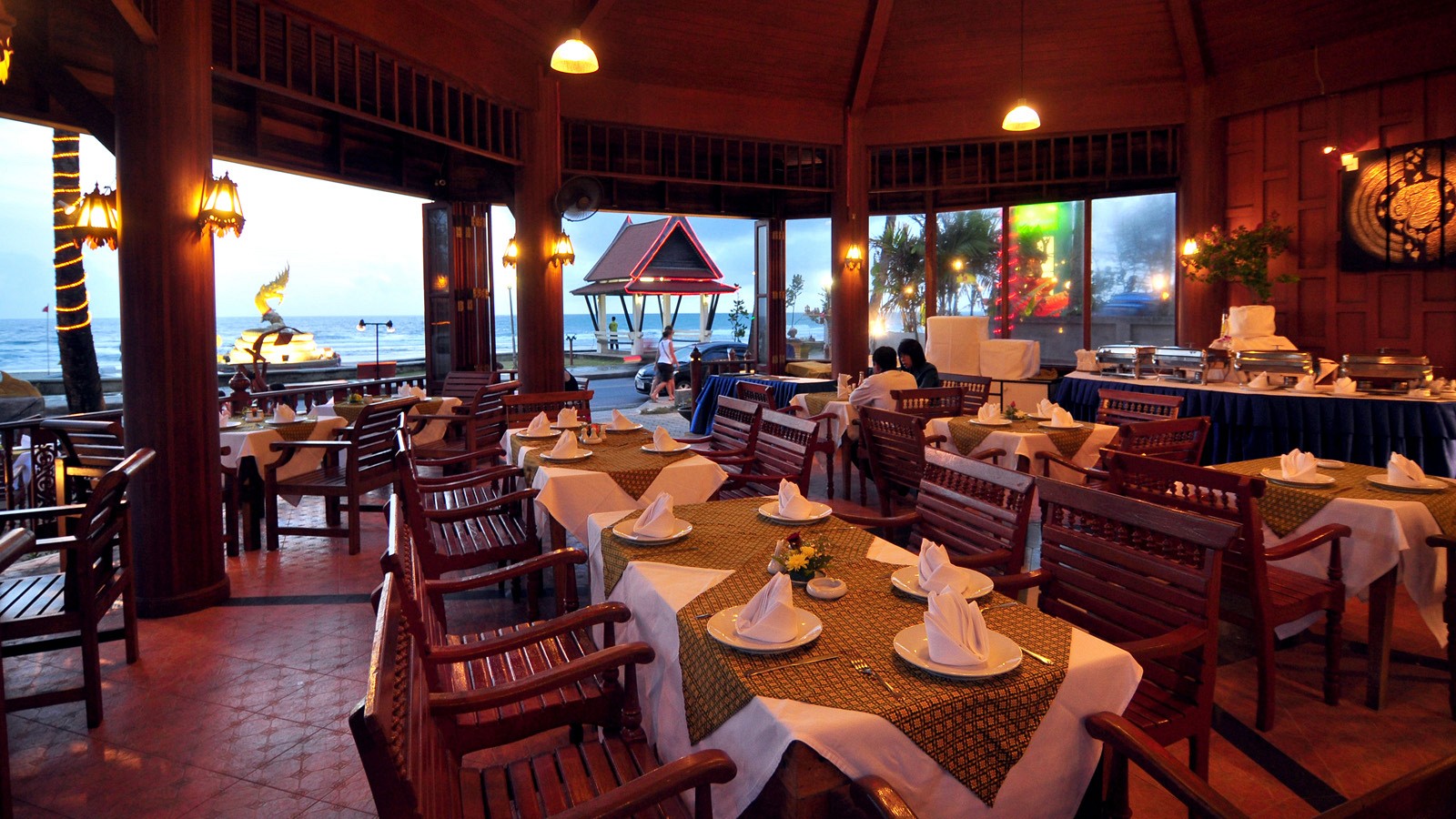 ห้องอาหารริมทะเลของ Baan Karonburi Resort ยามพลบค่ำ มองเห็นหาดกะรนและทะเลอันดามันตรงหน้า