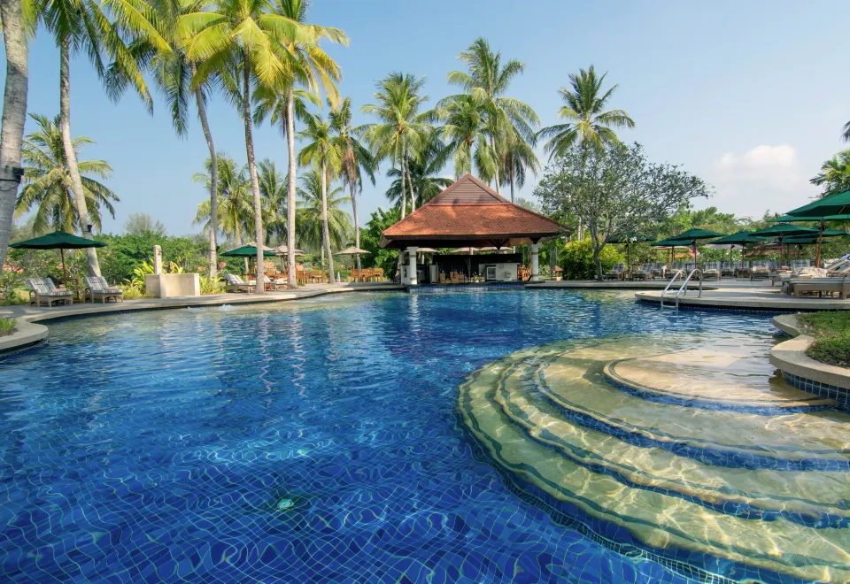 สระว่ายน้ำกลางแจ้งของ Banyan Tree Phuket ท่ามกลางต้นปาล์มและสวนเขตร้อน
