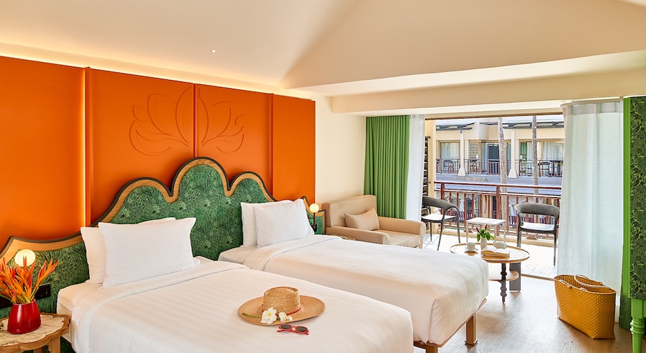 ห้อง Elite Pool View ของ Burasari Phuket เตียงคู่หัวเตียงลายดอกบัวสีส้ม-เขียว พร้อมระเบียงมองลงสระ