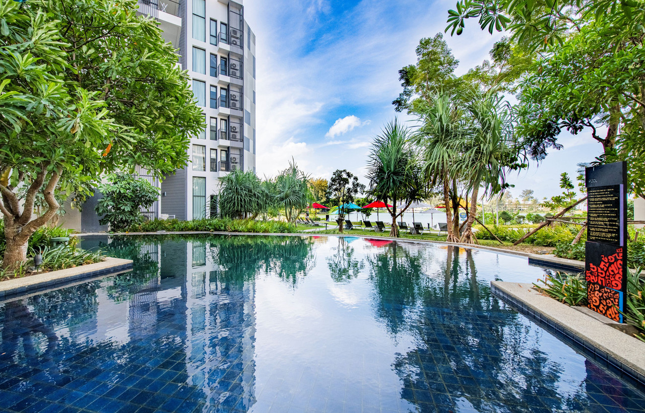 Swimming pool and residence towers at Cassia Phuket overlooking the Laguna Phuket lagoon