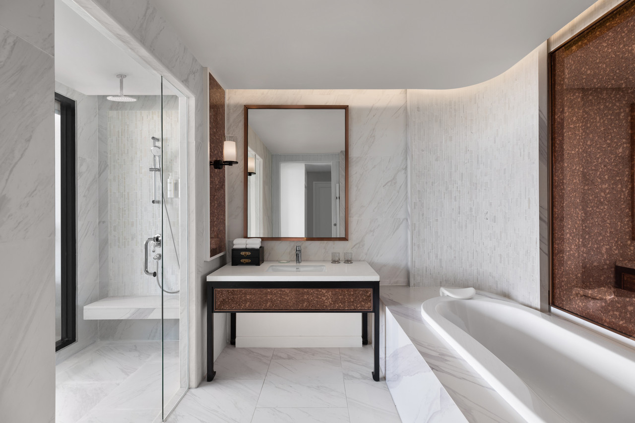 ห้องน้ำหินอ่อนของ Courtyard by Marriott Phuket Town พร้อมอ่างอาบน้ำและฝักบัว rainshower ลายกระเบื้องเปอรานากัน