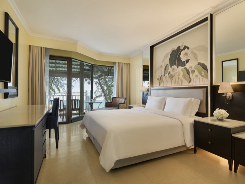 Premier Ocean Front room at Dusit Thani Laguna Phuket with lotus artwork above the bed and a balcony facing Bang Tao Beach