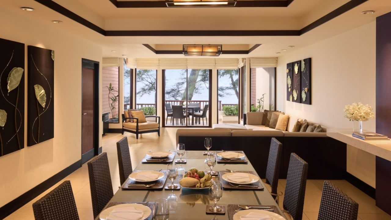 Living and dining room of the Two-Bedroom Pool Villa at Dusit Thani Laguna Phuket opening onto a sea-view terrace