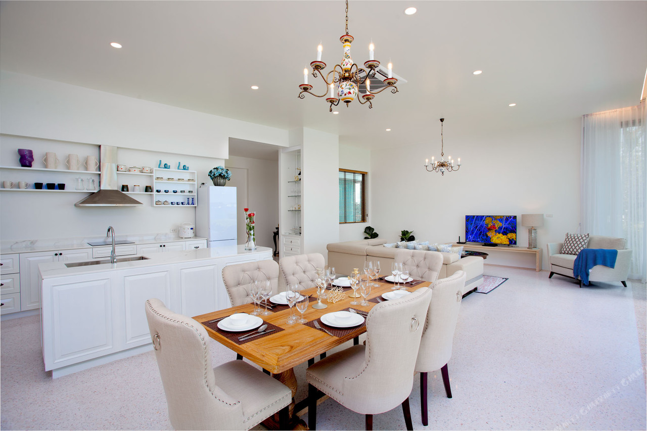 ครัวเต็มรูปแบบแบบเปิดโล่งพร้อมโต๊ะทานข้าวในวิลลาของ Fisherman Way Beach Villa ภูเก็ต