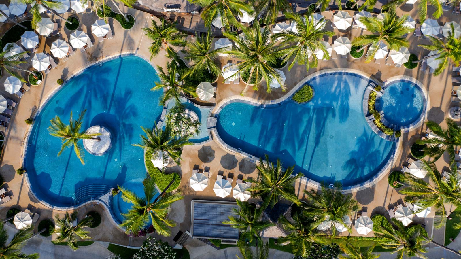 มุมสูงสระว่ายน้ำรูปทรงอิสระ 2 สระท่ามกลางมะพร้าวของ Katathani Phuket Beach Resort