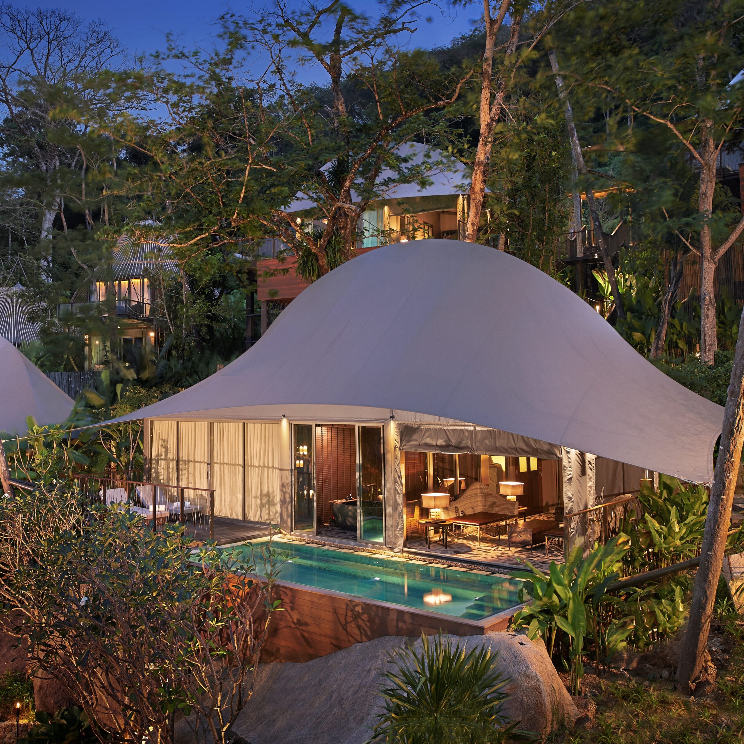 Tent Pool Villa ของ Keemala ยามค่ำ หลังคาผ้าใบโค้งพร้อมสระส่วนตัวท่ามกลางป่า