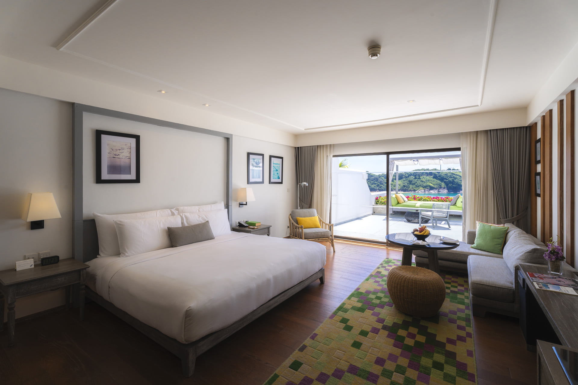 A Grand Ocean View room at The Nai Harn with a King bed, seating area and sea-view terrace