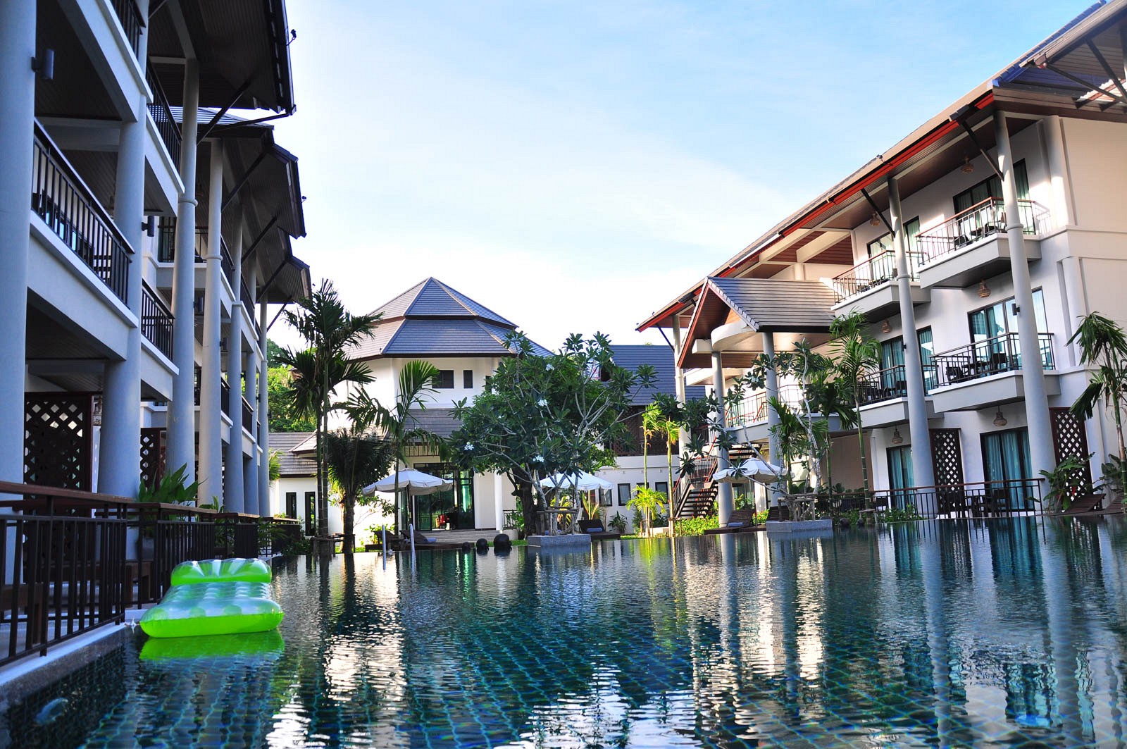 สระว่ายน้ำเกลือยาวของ Navatara Phuket Resort ขนาบด้วยอาคารห้องพักสไตล์ไทย-โมเดิร์นและศาลาทรงจั่ว