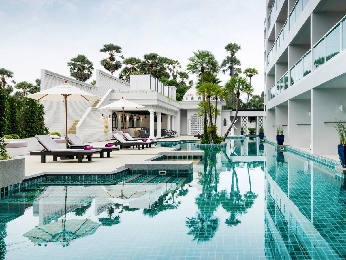 สระว่ายน้ำกลางแจ้งของ Chanalai Romantica Resort ล้อมด้วยห้อง Pool Access ที่ก้าวจากระเบียงลงสระได้