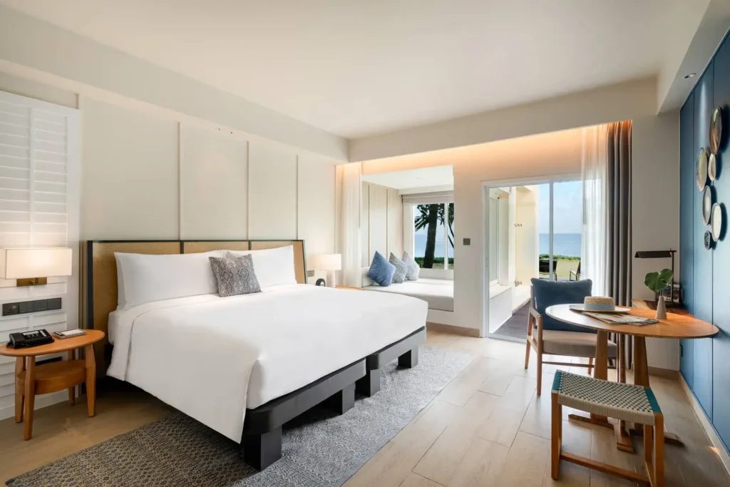 ห้อง Beach Access ของ SAii Laguna Phuket โทนขาว-ฟ้าหลังรีโนเวต เปิดประตูเห็นสนามหญ้าและทะเล