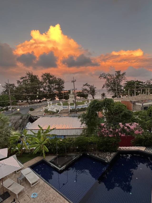 The upper pool at Sugar Marina ART at sunset, looking out over Karon circle and the sea in the distance
