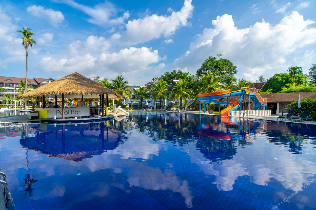 สระว่ายน้ำหลักของ Sunwing Kamala Beach พร้อมพูลบาร์หลังคาจากและสไลเดอร์น้ำสีส้ม-น้ำเงิน