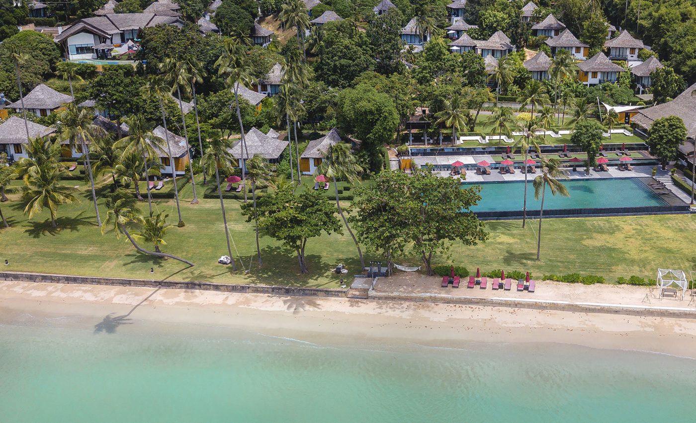 Aerial view of Friendship Beach on Chalong Bay with the infinity pool and wide lawns of The Vijitt Resort