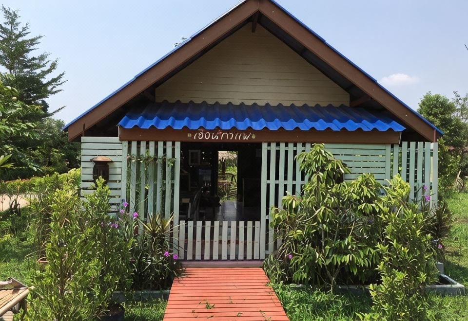 ห้องพักของ ปานพิมพ์ รีสอร์ต ปราจีนบุรี เตียงสบายและมีเทอเรซมองออกไปเห็นสวน
