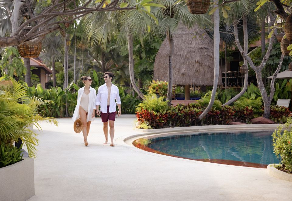 สระว่ายน้ำกลางแจ้งของ Anantara Hua Hin ล้อมรอบด้วยต้นไม้เขียวครึ้ม