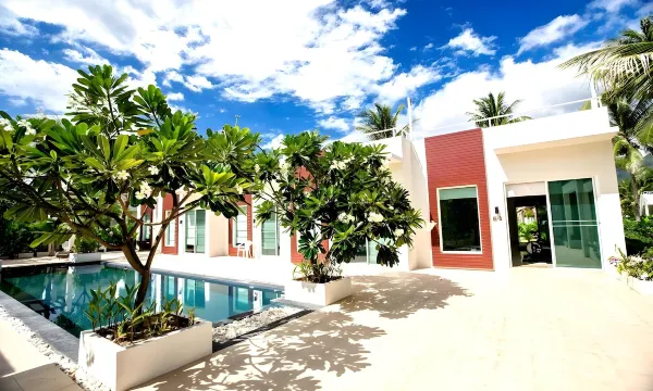 สระว่ายน้ำกลางแจ้งของ The Beach Village Resort ในสวนมะพร้าวร่มรื่นที่สามร้อยยอด