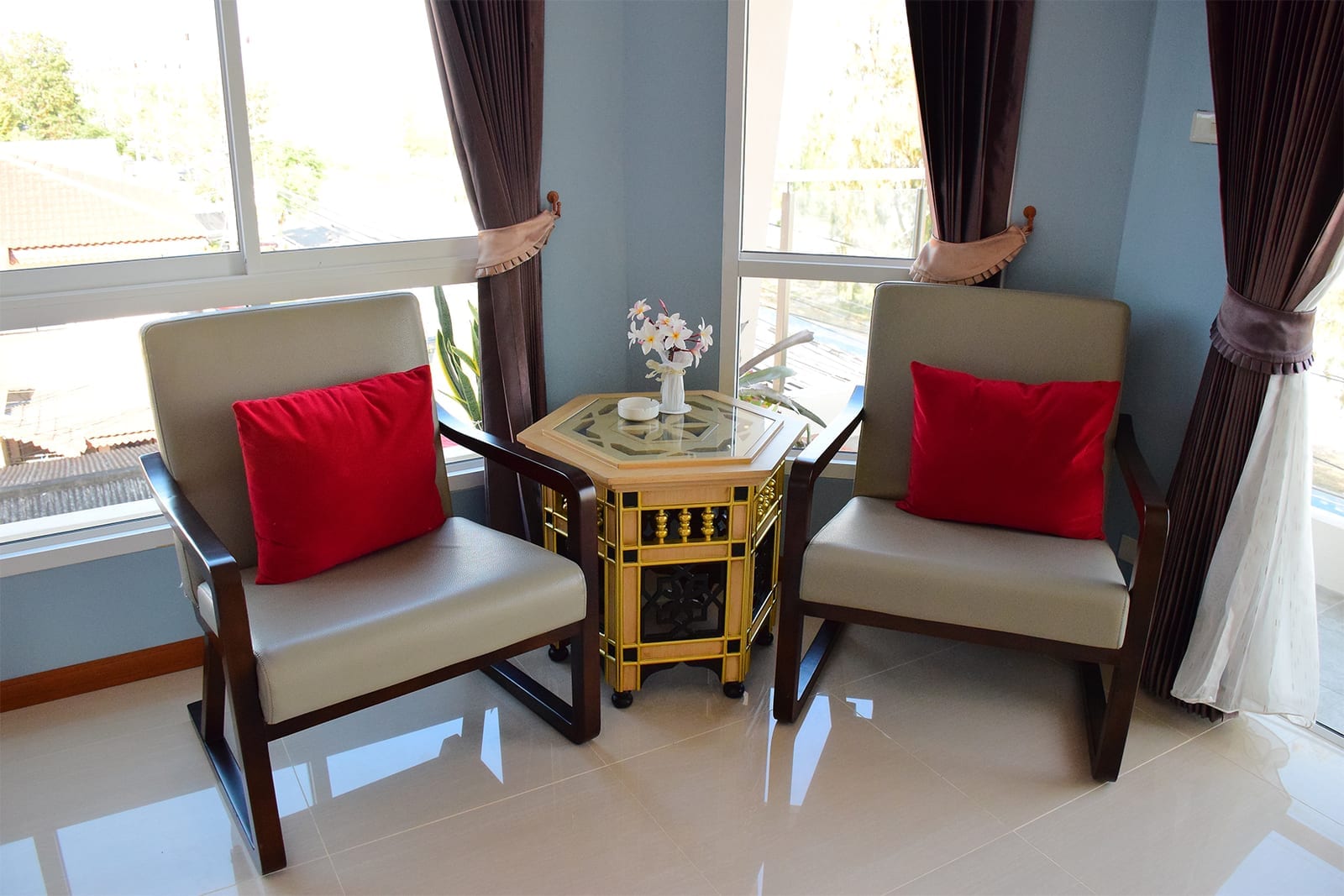 มุมนั่งเล่นริมหน้าต่างห้องวิวทะเลของ Golden Beach Boutique Resort พร้อมเก้าอี้และโต๊ะเล็ก