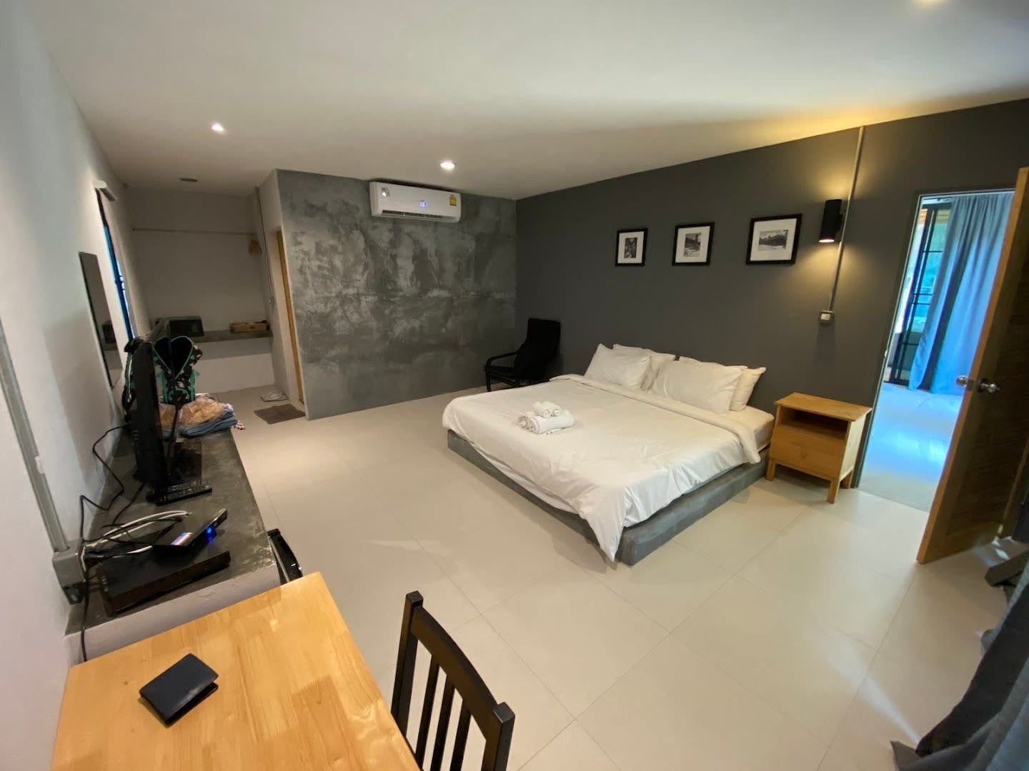 ห้องพักสไตล์ลอฟท์ของ The Loft Berry Resort ผนังปูนเปลือยโทนเทา เตียงนุ่ม และโซนนั่งเล่นกว้าง