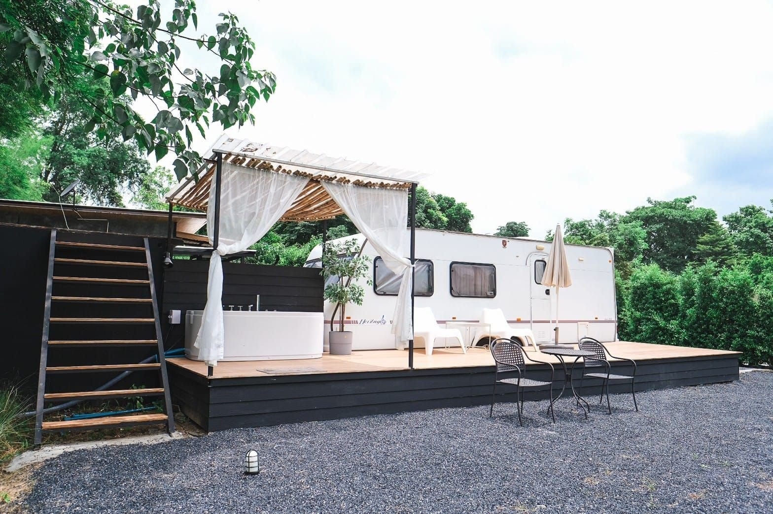 ห้องพักแบบรถบ้าน (Caravan) ของ The Loft Berry Resort พร้อมเทอเรซไม้และอ่างอาบน้ำกลางแจ้ง