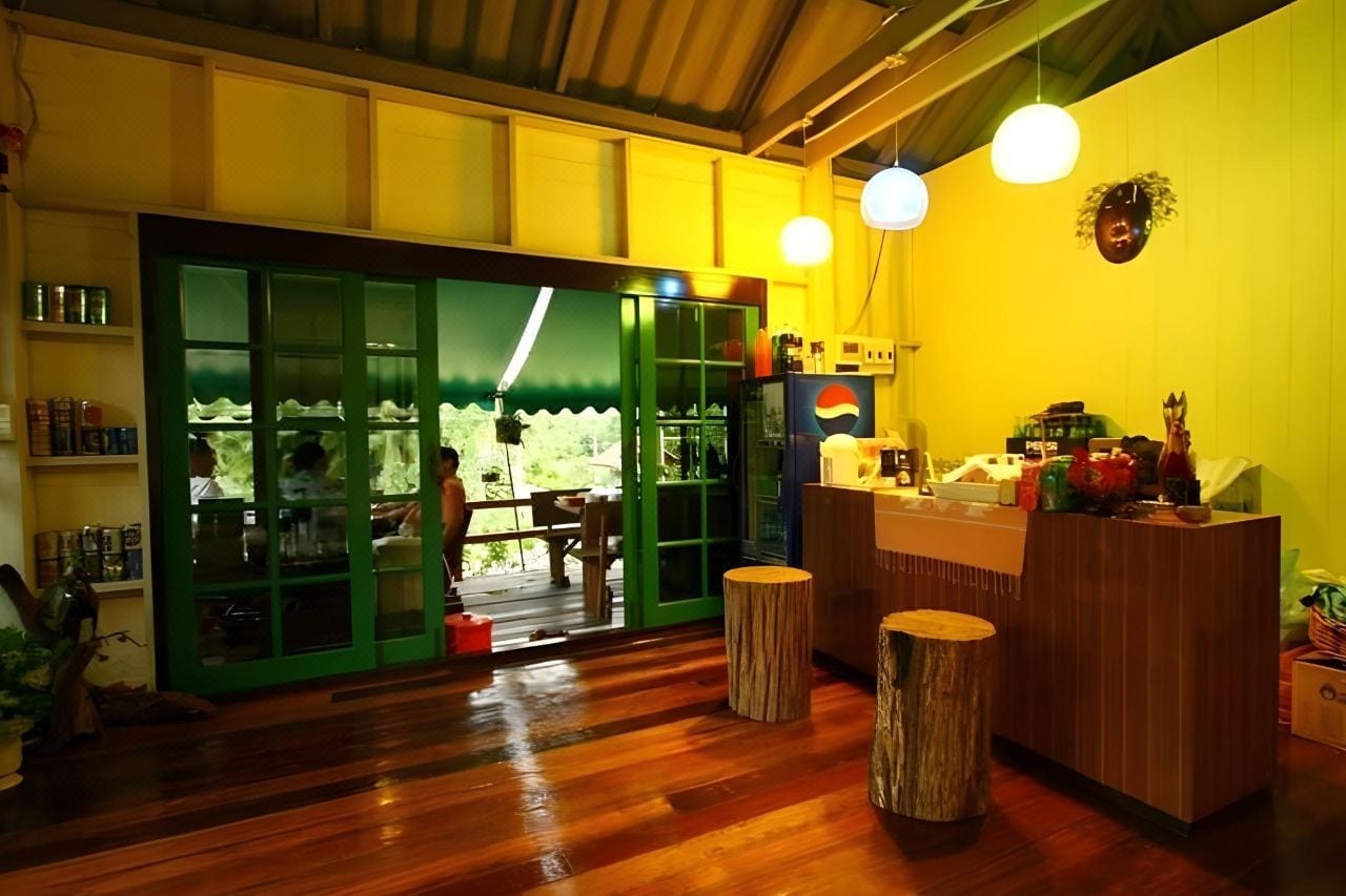 บ้านพักและมุมพักผ่อนของ Phumalida Resort ท่ามกลางต้นไม้เขียวและวิวภูเขาสวนผึ้ง