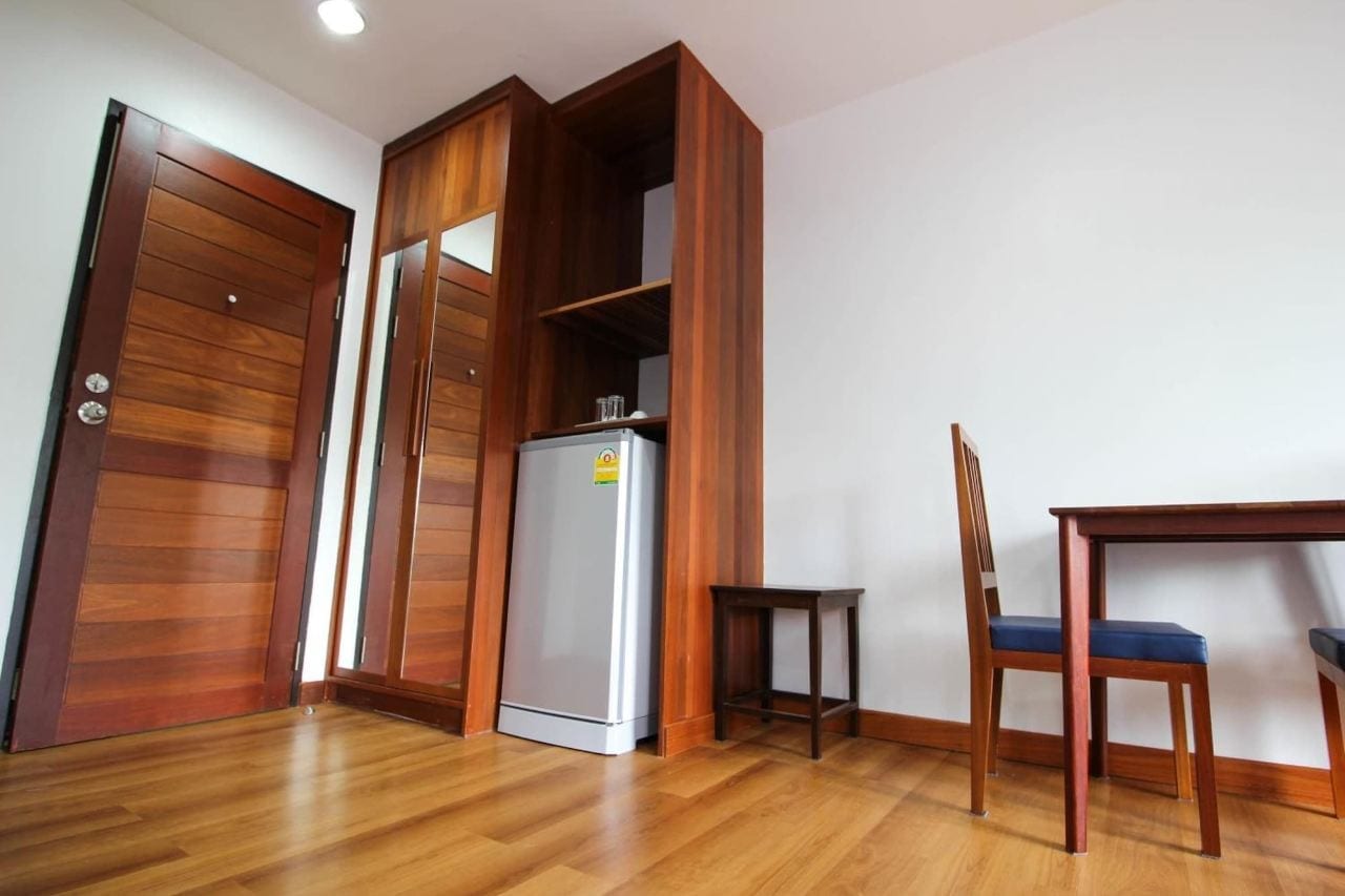 ห้องพักของ Tai-Shan Suites ตกแต่งด้วยงานไม้สัก มีตู้เย็นและโต๊ะทำงาน